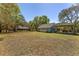 Spacious property featuring a detached garage and carport amid a lush, grassy landscape with mature trees at 10159 Se 174Th St, Summerfield, FL 34491