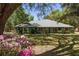 Landscaped front yard featuring mature trees, a well-manicured lawn, and a charming one-story home at 10159 Se 174Th St, Summerfield, FL 34491