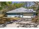 Side view of the house showing the garage door, blue walls, and driveway at 10159 Se 174Th St, Summerfield, FL 34491