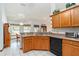 Bright kitchen featuring wooden cabinets, countertops, and modern appliances, enhanced by tile flooring at 10159 Se 174Th St, Summerfield, FL 34491