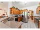 Well-lit kitchen featuring wooden cabinetry, modern stainless steel appliances, and tile flooring, offering ample counter space at 10159 Se 174Th St, Summerfield, FL 34491