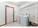 Functional laundry room with tile flooring, washer, dryer, utility sink, and shelving at 10159 Se 174Th St, Summerfield, FL 34491