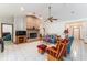 Spacious living room featuring a brick fireplace, tile floors, and a ceiling fan, creating a welcoming gathering space at 10159 Se 174Th St, Summerfield, FL 34491
