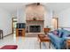 Cozy living room featuring a brick fireplace, tile flooring, and comfortable seating, perfect for relaxation and gatherings at 10159 Se 174Th St, Summerfield, FL 34491