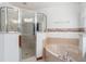 Bright bathroom featuring a walk-in shower and tub with a stylish shower door, perfect for relaxation at 10159 Se 174Th St, Summerfield, FL 34491
