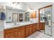 Well-lit bathroom featuring a dual-sink vanity with plenty of counter space, a mirror, and white tiled floors at 10159 Se 174Th St, Summerfield, FL 34491
