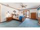 Inviting main bedroom with blue carpet and a private entry through glass doors to an outdoor space at 10159 Se 174Th St, Summerfield, FL 34491