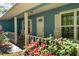 Welcoming front porch with rocking chairs, beautiful flower garden and lots of curb appeal at 10159 Se 174Th St, Summerfield, FL 34491