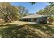 Backyard view of an attractive blue home with a covered patio area at 10159 Se 174Th St, Summerfield, FL 34491