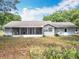 View of the backyard featuring a screened in porch and well maintained lawn at 10323 Joanies Run, Leesburg, FL 34788