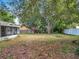 A lush green backyard with mature trees providing shade, creating a tranquil and private outdoor space at 10323 Joanies Run, Leesburg, FL 34788