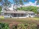 A charming single-story home with a screened-in porch and a spacious backyard filled with lush greenery at 10323 Joanies Run, Leesburg, FL 34788