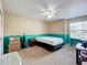 Bright bedroom featuring neutral walls accented by a vibrant turquoise trim, ceiling fan, and plush carpeting at 10323 Joanies Run, Leesburg, FL 34788