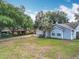 Quaint single-story home with a well-manicured lawn, a palm tree, and an attached garage with a basketball hoop at 10323 Joanies Run, Leesburg, FL 34788
