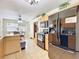 Eat-in kitchen boasts tile floors, modern black appliances, and natural wood cabinets at 10323 Joanies Run, Leesburg, FL 34788