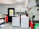 Functional laundry room with washer, dryer, storage cabinets, and door to the exterior at 10323 Joanies Run, Leesburg, FL 34788