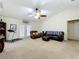 Bright living room with vaulted ceiling, carpet, and access to the lanai at 10323 Joanies Run, Leesburg, FL 34788