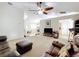 Spacious living room features neutral walls, plush carpeting, a ceiling fan, and a comfortable seating arrangement at 10323 Joanies Run, Leesburg, FL 34788