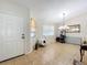 A welcoming living room bathed in natural light, featuring tile floors and a view of the entry and living spaces at 10323 Joanies Run, Leesburg, FL 34788