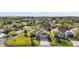 Aerial view of a home with a well-manicured lawn and mature trees in a residential neighborhood at 1061 Woodruff St, The Villages, FL 32162