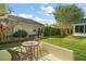 Inviting backyard featuring a quaint patio, a lush green lawn, and mature landscaping for privacy and enjoyment at 1061 Woodruff St, The Villages, FL 32162