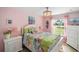 Cozy bedroom showcasing bright tropical bedding, flamingo decor, and natural light from the window at 1061 Woodruff St, The Villages, FL 32162