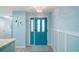 Bright foyer with a teal door, decorative chandelier, and wainscoting at 1061 Woodruff St, The Villages, FL 32162