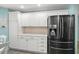 Kitchen boasts white cabinets and stainless steel refrigerator at 1061 Woodruff St, The Villages, FL 32162