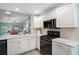 Modern kitchen with stainless appliances, quartz counters, and open layout to the living area at 1061 Woodruff St, The Villages, FL 32162
