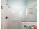 Bright shower featuring white tiling, glass doors, and convenient grab bar for added safety and accessibility at 1061 Woodruff St, The Villages, FL 32162