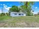 Quaint single-story home featuring a lush green lawn, large trees, and an attached garage at 1109 Hampton St, Clermont, FL 34711