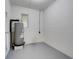 Utility room featuring a water heater, painted block wall, and concrete floor at 1109 Hampton St, Clermont, FL 34711