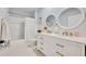 Well-lit bathroom featuring double sinks with gold hardware and trim, white cabinets, and modern fixtures at 113 Camilla Rd, Deland, FL 32724