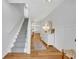 Inviting hallway with wood floors, leading to a staircase, with decorative lighting and decor providing an elegant touch at 113 Camilla Rd, Deland, FL 32724