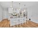 Bright, open kitchen featuring a center island with seating, modern pendant lighting, and stainless steel appliances at 113 Camilla Rd, Deland, FL 32724