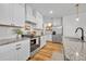 Well-lit kitchen with stainless steel appliances, granite countertops, white cabinetry, and wood-look flooring at 113 Camilla Rd, Deland, FL 32724
