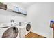 Laundry room featuring a white washer and dryer and wire shelving with storage bins at 113 Camilla Rd, Deland, FL 32724