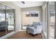This bright sunroom has a striped chair and lots of windows at 1208 Santa Cruz Dr, The Villages, FL 32162