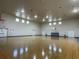 Large, indoor basketball court with hardwood flooring, basketball hoops, and many doors at 130 Southern Pecan # 105, Winter Garden, FL 34787