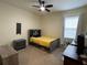 A well-lit bedroom with a ceiling fan, window, and comfortable bed at 130 Southern Pecan # 105, Winter Garden, FL 34787