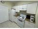 Efficient kitchen with white appliances and cabinetry, and tile floors at 130 Southern Pecan # 105, Winter Garden, FL 34787