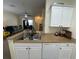 Functional kitchen featuring a stainless steel sink, white cabinetry and granite countertops at 130 Southern Pecan # 105, Winter Garden, FL 34787
