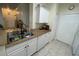 Functional kitchen featuring a stainless steel sink, white cabinetry and granite countertops at 130 Southern Pecan # 105, Winter Garden, FL 34787