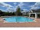 Community swimming pool on a sunny day with lounge chairs, blue water, and landscaped grounds at 130 Southern Pecan # 105, Winter Garden, FL 34787