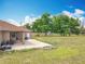 Spacious backyard featuring a covered patio and a large grassy area with mature trees at 13013 County Road 561A, Clermont, FL 34715