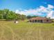 Spacious backyard featuring a well-maintained lawn, mature trees, and a patio area perfect for outdoor gatherings at 13013 County Road 561A, Clermont, FL 34715