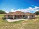 Wide backyard view of a home featuring a covered patio and expansive lawn area at 13013 County Road 561A, Clermont, FL 34715