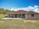Home exterior with covered patio, spacious backyard, and well-maintained lawn at 13013 County Road 561A, Clermont, FL 34715