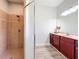 Bathroom featuring a glass shower with tile surround and vanity with dark cabinets and a marble countertop at 13013 County Road 561A, Clermont, FL 34715