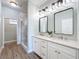 Modern bathroom featuring a double vanity, stylish mirrors, and a glass-enclosed shower at 13013 County Road 561A, Clermont, FL 34715